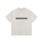 Beige t-shirt with 'GROUNDED' text on a white background